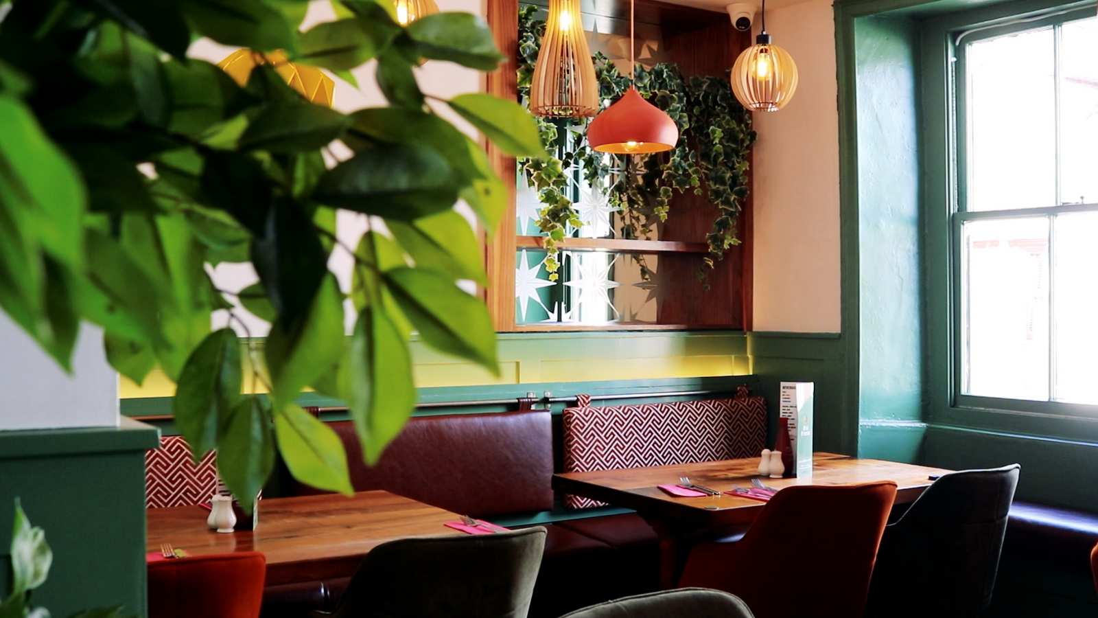 Inside Piri Fresco: sage green panelling, rattan pendants and cosy booths